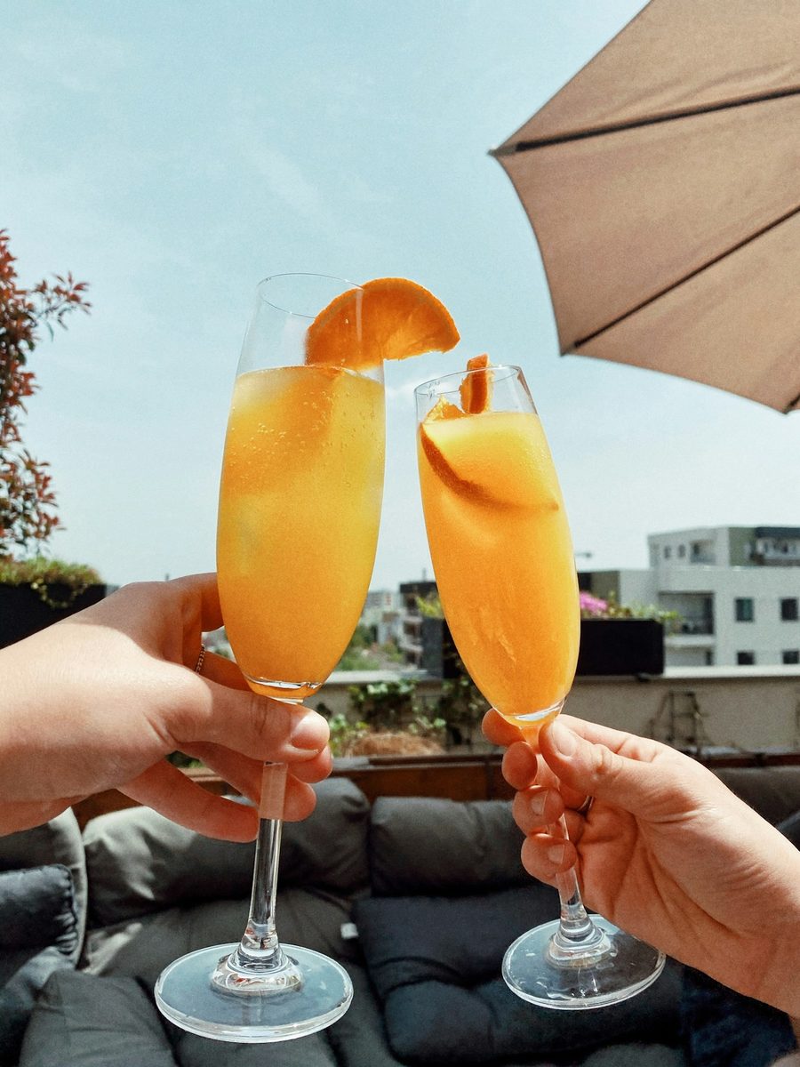 Caramel apple mimosas in sugar-rimmed flutes garnished with apple slices